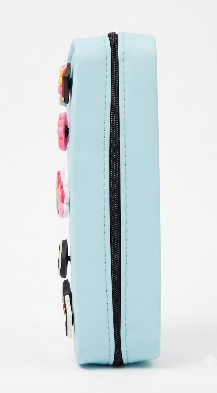 Profil de la trousse bleue avec sa fermeture éclair et des charms sur la tranche