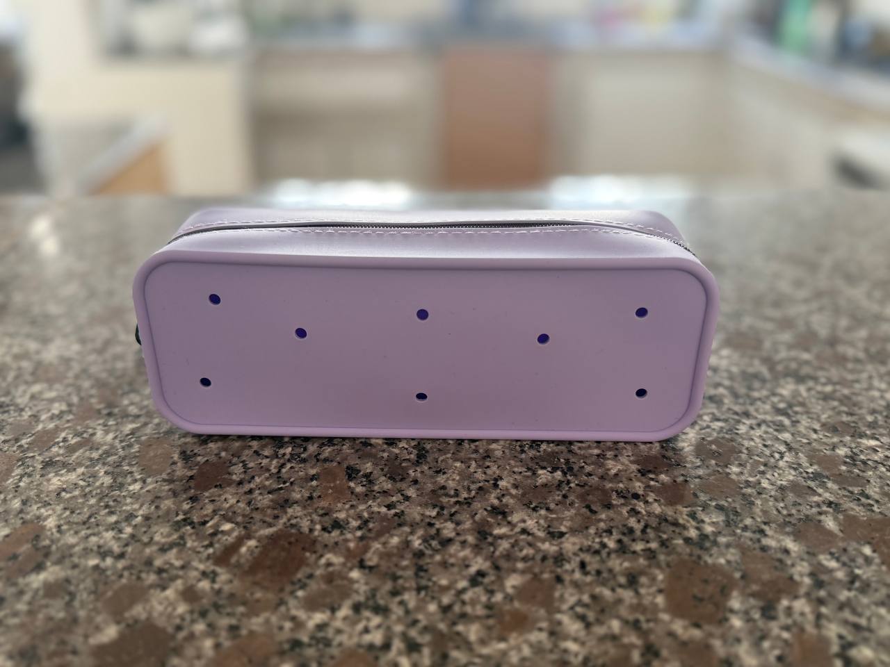 Trousse Dodoupi lavande montrant les trous prévus pour clipser les charms